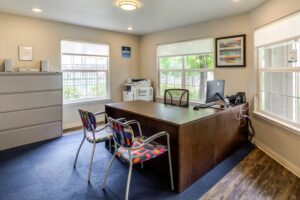 Management Office, blue carpet and wood floors, large well lit windows