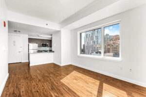 Unit Kitchen/Living room, hardwood floors, large widow with view of city, white walls