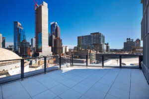 Unit Terrace, large, sprawling view of the city, metal & glass handrail, concrete floor.