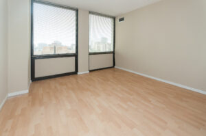 Unit Living room, Wood floors, 2 large windows, tan colored walls.