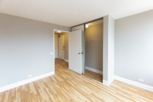 Unit Bedroom, Mirrored Sliding closet doors, Wood Floors, Unit Entrance across from bedroom.