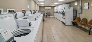 Interior Laundry Facilities, Industrial washer and dryer machines, Tile Flooring, Waiting Bench, Stainless steel Industrial sink.