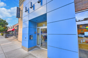 Exterior Entrance, Blue contemporary panelled facade, lincoln park plaza signage, shops neighboring Lincoln park plaza.