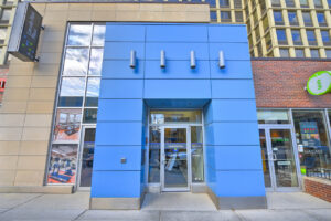 Exterior Entrance, Blue contemporary panelled facade, lincoln park plaza signage, shops neighboring Lincoln park plaza.
