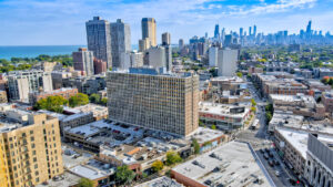 Aerial Exterior of lincoln park plaza and surrounding businesses, photo taken on a sunny day, Skyline in background.